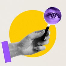 se ve una mano que sostiene una lupa que apunta a ver el acercamiento de un ojo