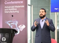 hombre hablando frente a un escenario, dando una conferencia