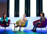 tres mujeres sentadas en una conferencia