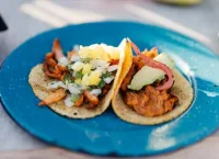 imagen de unos tacos de pastor a la mexicana con piña en un plato azul