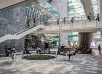 Toma del pasillo interior del edificio de la biblioteca del Tec de Monterrey, se observan estudiantes caminando por corredores y subiendo escaleras.