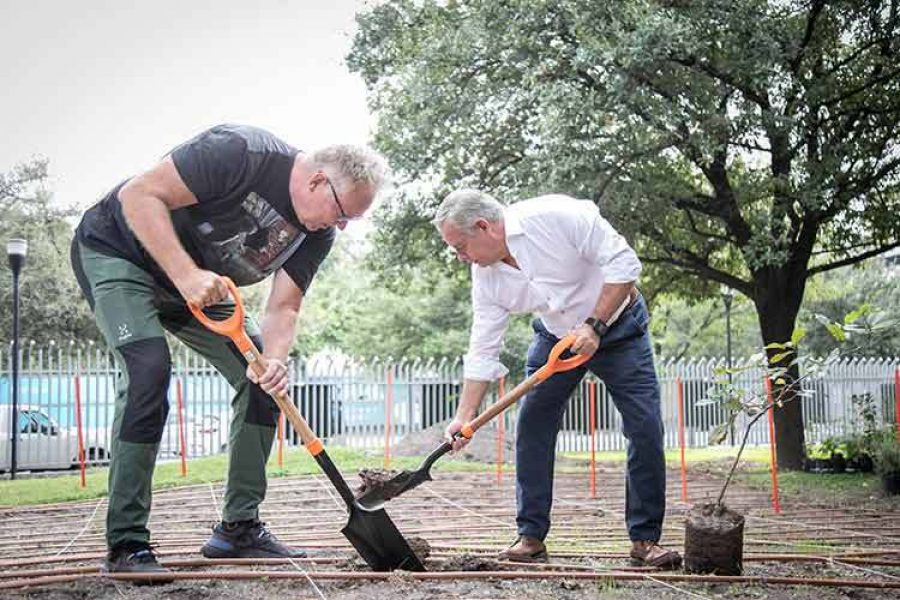 Profesor y directivo del Tec sostienen palas antes de plantar un arbol.